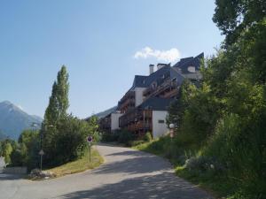 a road with a building on the side of a mountain at Appart Duplex 8 pers avec Terrasse à Pra-Loup - FR-1-165A-170 in Uvernet-Fours