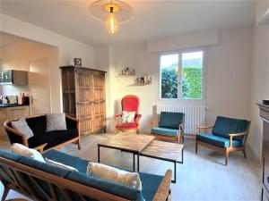 ein Wohnzimmer mit Sofa, Stühlen und einem Tisch in der Unterkunft Maison avec Jardin, WIFI, proche plage et commerces, calme - Perros-Guirec - FR-1-368-374 in Perros-Guirec + 7 Fotos