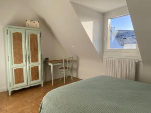 a bedroom with a bed and a table and a window at Maison avec Jardin, WIFI, proche plage et commerces, calme - Perros-Guirec - FR-1-368-374 in Perros-Guirec