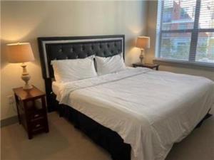 um quarto com uma grande cama branca e 2 candeeiros em Resort-Style Apartments near The Galleria em Houston