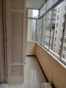 Habitación vacía con ventana y puerta blanca en Real Apartments 399 - 3 quartos e 2 banheiros na quadra da Praia de Copacabana, en Río de Janeiro
