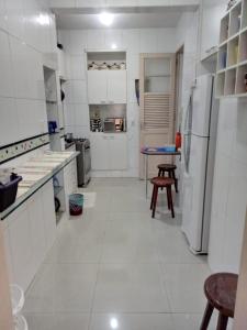 una cocina con electrodomésticos blancos y una mesa. en Real Apartments 399 - 3 quartos e 2 banheiros na quadra da Praia de Copacabana, en Río de Janeiro