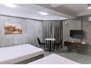 a bedroom with a bed and a desk and a television at OYO 925 Rcee Place in Cebu City