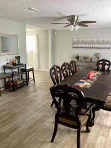 a living room with a dining room table and chairs at Very Private 3 Bed Home with HEATED Pool Palms and Big Fenced Yard in Pensacola
