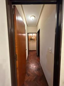 pasillo que conduce a una habitación con puerta y suelo de madera en Departamento temporario Maipú 700, Barrio Norte en San Miguel de Tucumán