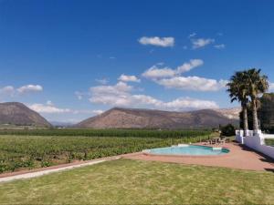 a swimming pool in a field with mountains in the background at DuVon Farmhouse in Robertson