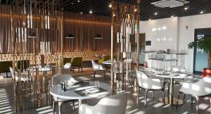 a restaurant with tables and chairs in a room at Ramada Plaza by Wyndham Jaeun in Sinan
