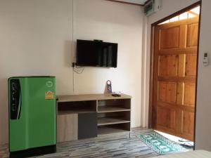 a green refrigerator in a room with a tv at COWORX Koh Lanta in Ban Mo Nae
