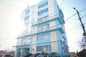 a blue and white building with cars parked in front of it at Luana Airport Apartments #3 in Otopeni