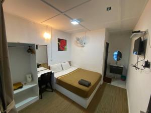 een slaapkamer met een bed, een bureau en een televisie bij Darulmakmur Chalet in Cameron Highlands