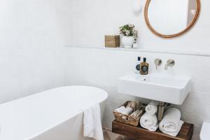 een witte badkamer met een wastafel en een spiegel bij The Oaks Ranch in Tomakin