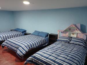 a bedroom with two beds and a crib in it at Habitación Privada (15m2) - Baño Compartido in Cajamarca