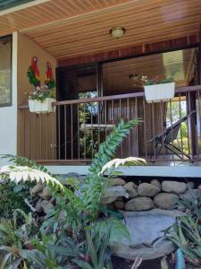 um alpendre de uma casa com dois pássaros na varanda em Cabaña en Alajuela en lugar tranquilo y con mucha naturaleza. em Tambor