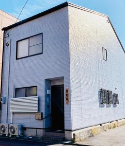 um edifício cinzento com uma porta ao lado em HOSTEL UKS - Vacation STAY 13007 em Nagoia