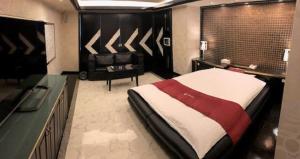 Dormitorio con cama, escritorio y TV en Prime Hotel Fulula プライムホテル フルーラ en Osaka