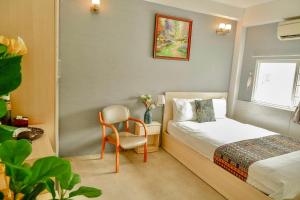 1 dormitorio pequeño con 1 cama y 1 silla en Galaxy Boutique Sai Gon Central Hotel, en Ho Chi Minh