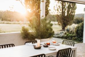 The Oaks Ranch في Tomakin: طاولة بيضاء مع كراسي وشموع على الفناء