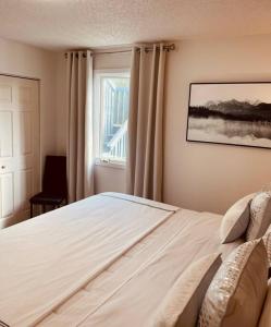a bedroom with a large white bed with a window at North Star Place 7 in Fairbanks