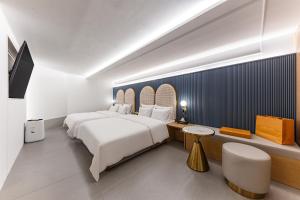 a hotel room with a large white bed and a desk at Brown Dot Hotel Cheonan Buldang in Cheonan