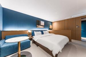 a hotel room with a bed and a blue wall at Brown Dot Hotel Cheonan Buldang in Cheonan