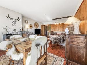a dining room and living room with a table and chairs at Between slopes and golf facing the Alps in Crans-Montana