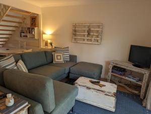 ein Wohnzimmer mit einem Sofa und einem TV in der Unterkunft Terrapin Apartment 4 in Noosaville
