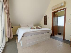 a bedroom with a bed with white sheets and a mirror at Blue Sky Pool Villa in Trat