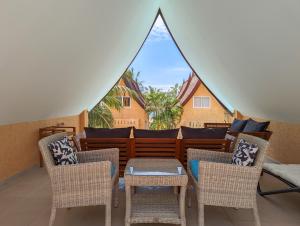 a porch with chairs and a table and a window at Blue Sky Pool Villa in Trat
