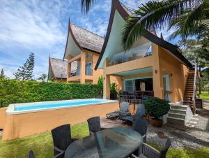 a house with a swimming pool in front of it at Blue Sky Pool Villa in Trat