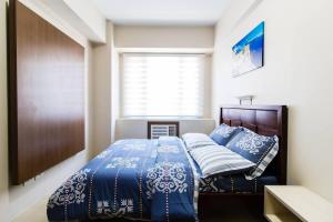 a bedroom with a bed with blue and white sheets at 2 BR Condo Apartment near NAIA 3 Pasay City in Manila +45 photos