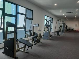 un gimnasio con varias máquinas de correr y ventanas en Cheras Lovely Studio House with Netflix and free car park, en Cheras