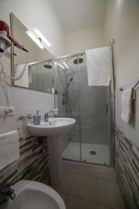 een badkamer met een douche, een wastafel en een toilet bij B&B La Colonna in Crotone