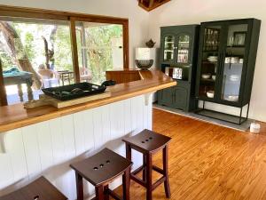 een keuken met een aanrecht en 2 krukken bij Imani Bush House & Silver Sky Chalet in Hluhluwe