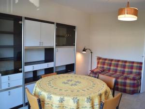 Zimmer mit einem Tisch, einem Stuhl und einem Sofa in der Unterkunft Cavalaire : Appartement 2 Pièces, à 300m Plage, Clim, Balcon - FR-1-226B-331 in Cavalaire-sur-Mer