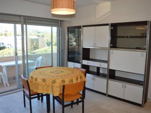 ein Esszimmer mit Tisch und Stühlen und einem Fenster in der Unterkunft Cavalaire : Appartement 2 Pièces, à 300m Plage, Clim, Balcon - FR-1-226B-331 in Cavalaire-sur-Mer