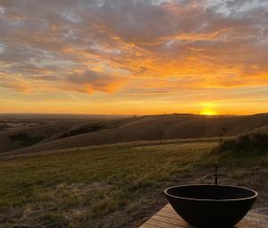 a bowl on a table with the sunset in the background at Wander on Kangaroo Island in Stokes Bay