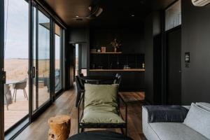 a living room with black walls and a couch and window at Wander on Kangaroo Island in Stokes Bay