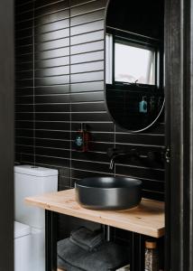 a black bathroom with a sink and a mirror at Wander on Kangaroo Island in Stokes Bay