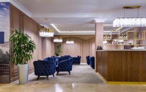 a restaurant with blue chairs and a bar at Mercure Tashkent in Tashkent +37 photos