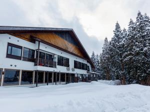 ein Gebäude mit Schnee davor in der Unterkunft kamosu mori in Tōkamachi