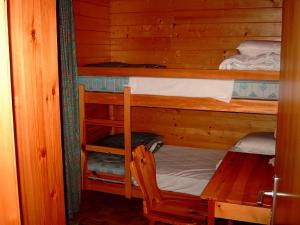 Zimmer mit 2 Etagenbetten und einem Tisch in der Unterkunft Chalet Solina in Icogne
