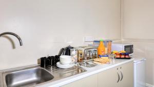 a kitchen counter with a sink and some food on it at Commercial Hotel Lockhart in Lockhart