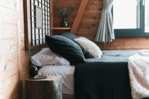 ein Schlafzimmer mit einem Bett mit Kissen darauf in der Unterkunft Sugi Chalet in Myōkō