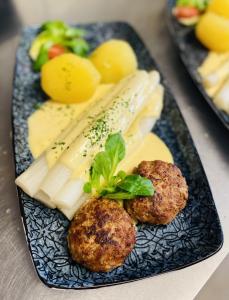 um prato de comida com almôndegas, queijo e legumes em Gasthof Bräustübl em Selb