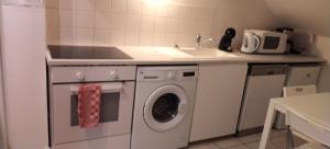 een keuken met een wasmachine en een wastafel bij Appart cosy Disney paris in Chalifert