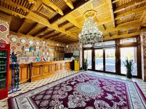 a large kitchen with a chandelier and a large rug at Zilol Baxt in Samarkand