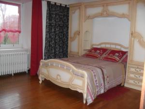 um quarto com uma cama grande e uma cabeceira em madeira em Gite de Peche em Saint-Ellier-du-Maine