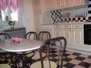 - une cuisine avec une table ornée de fleurs roses dans l'établissement Gite de Peche, à Saint-Ellier-du-Maine