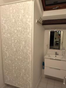 een badkamer met een schuifdeur met een wastafel bij Appart cosy Disney paris in Chalifert