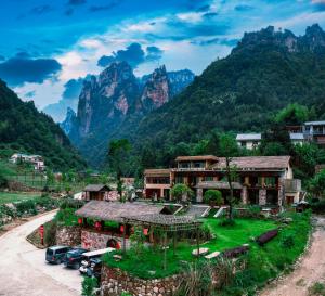 um resort com montanhas ao fundo em Homeward Mountain Resort em Zhangjiajie